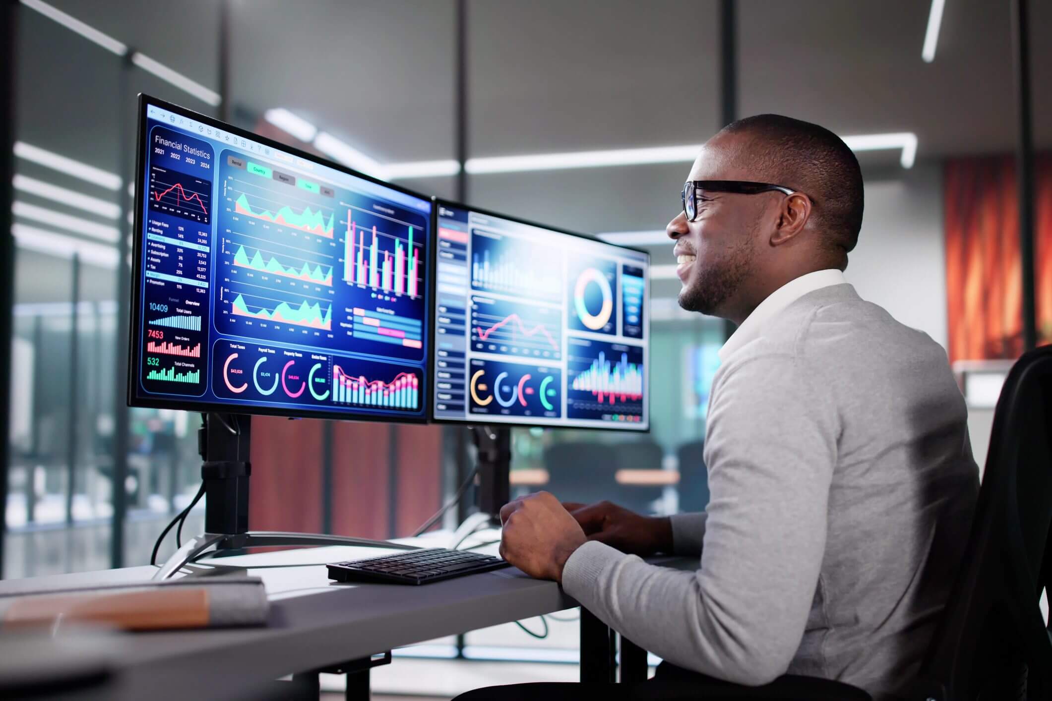 Man analyzing data on multiple monitors