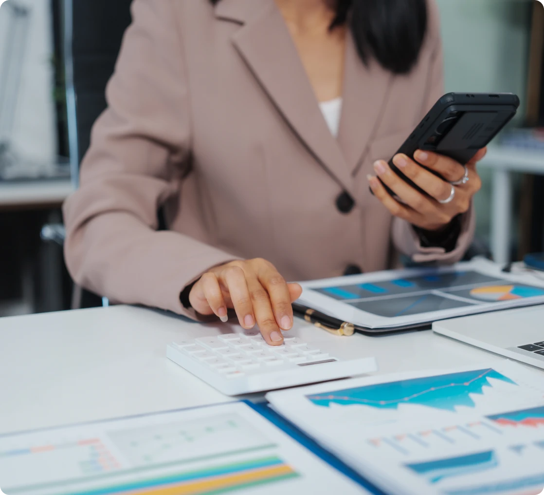 Businesswoman using calculator and smartphone