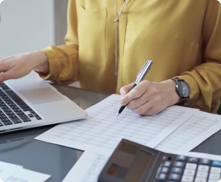 Office worker using calculator and laptop