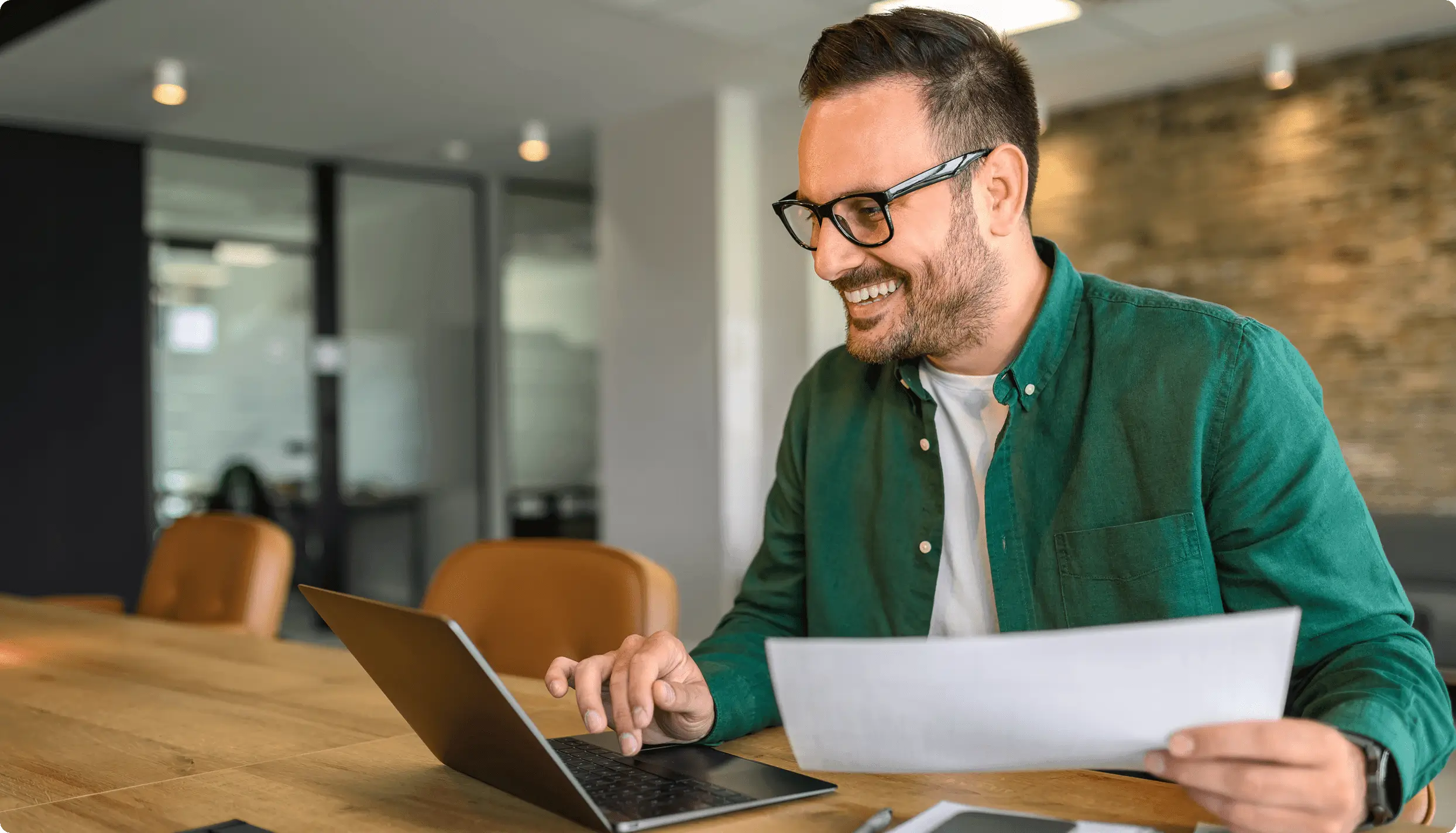 Happy man using laptop at desk